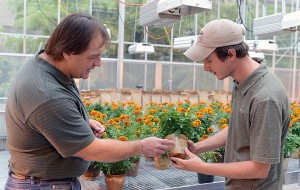 James Schrader, left, and Kenny McCabe examine a pot made from bioplastics. Photo by the Center for Crops Utilization Research.